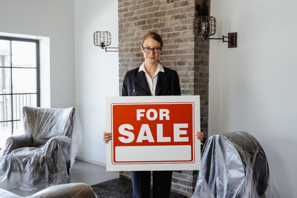 A-real-estate-agent-holding-a-sign