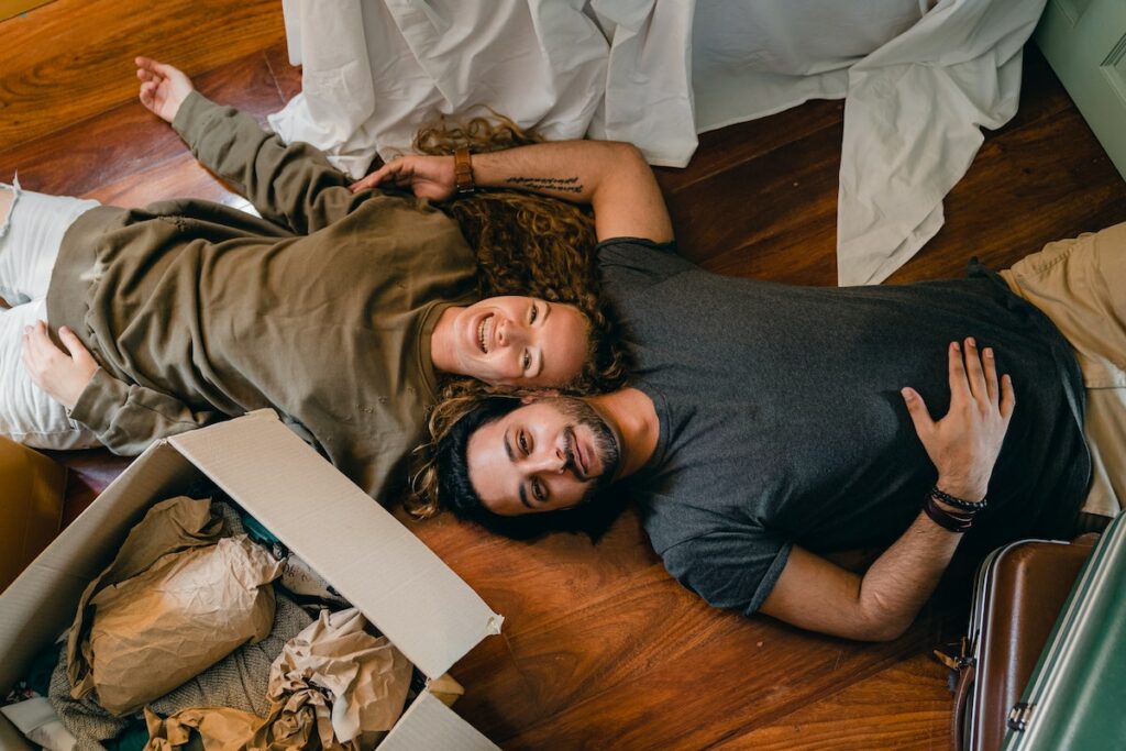 Cheerful-couple-lying-on-floor-and-laughing